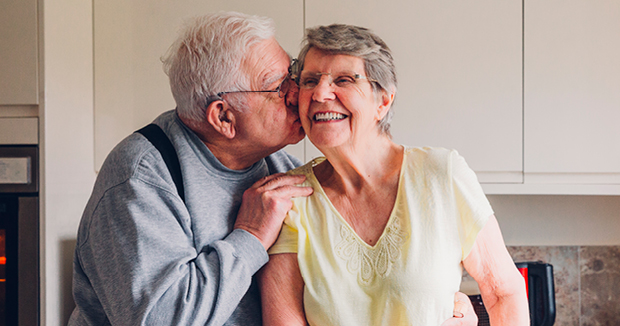 An elderly couple in their home happy